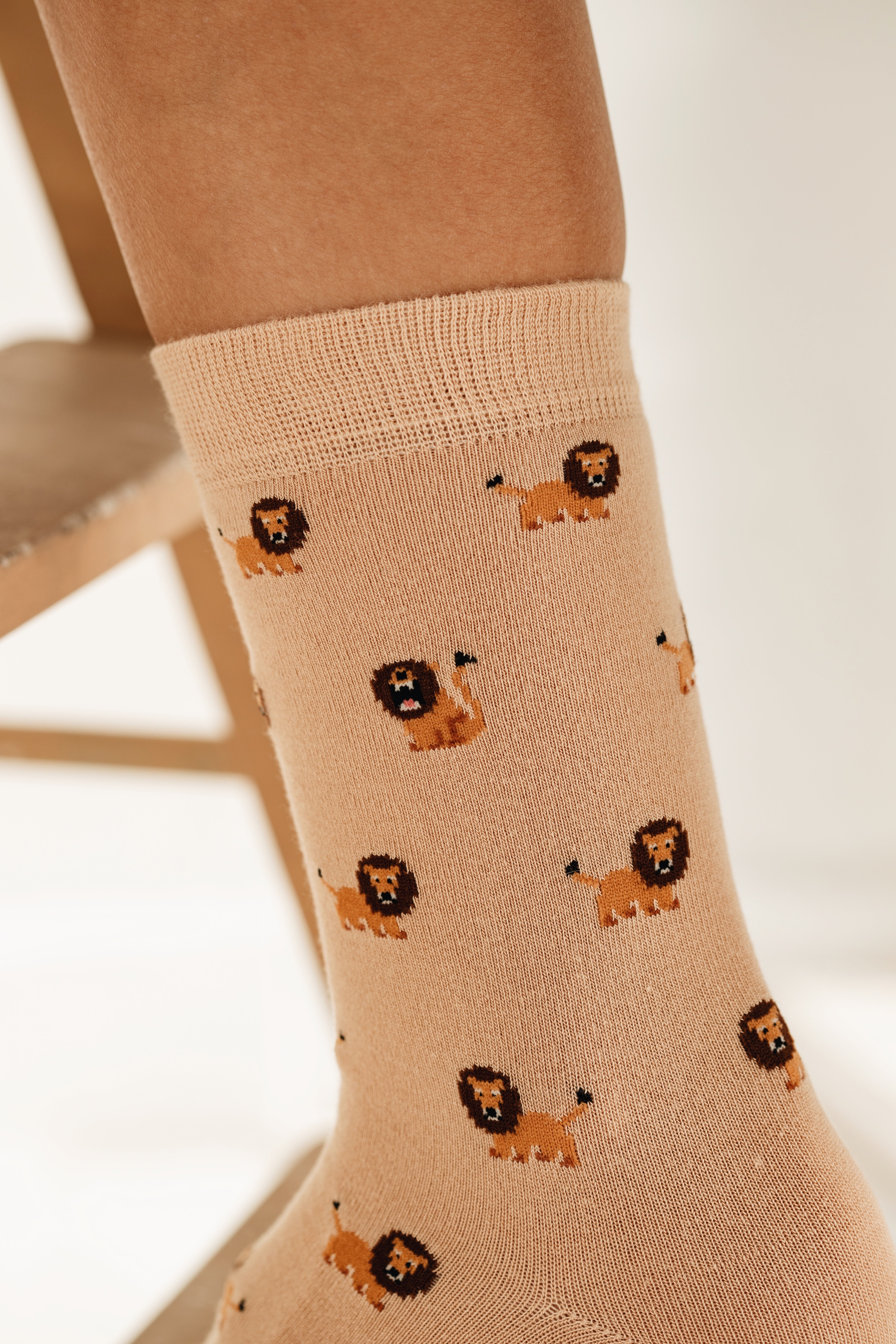 Trendige beige Socken mit Allover-Löwen-Print. Die hochwertige Verpackung mit dem Logo 'FUNDAZE' unterstreicht das moderne Design der Motiv-Socken.