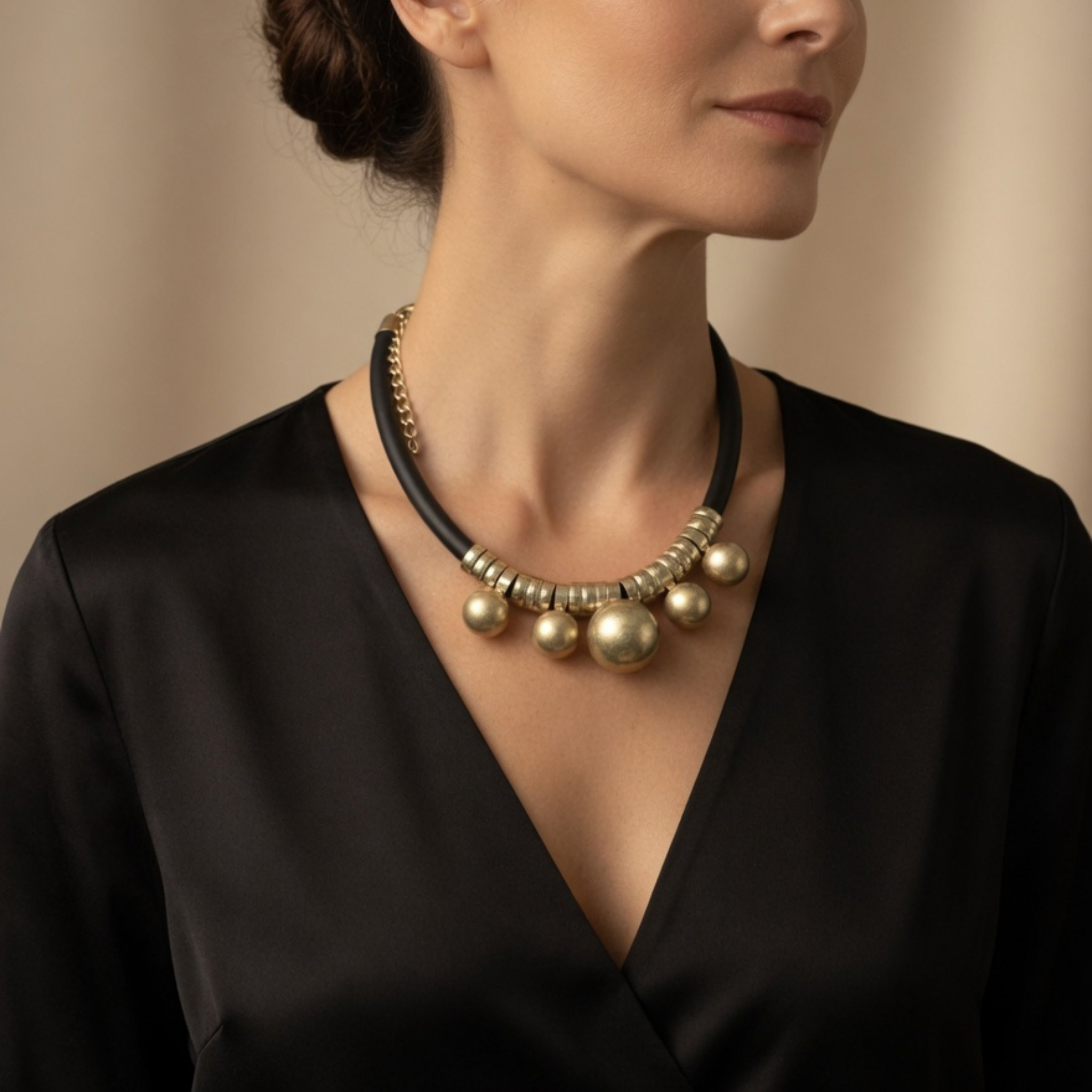 Schwarze Statement-Kette mit goldfarbenen Kugeln, getragen zu schwarzem Oberteil
