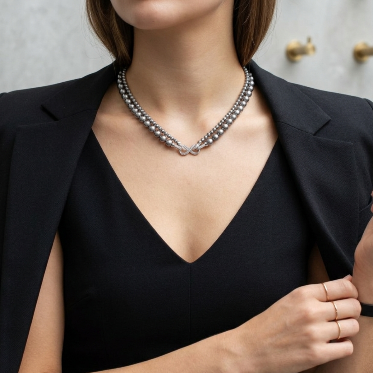 Zweireihige graue Perlenkette mit silberfarbenem Knotendetail, getragen zu schwarzem Blazer