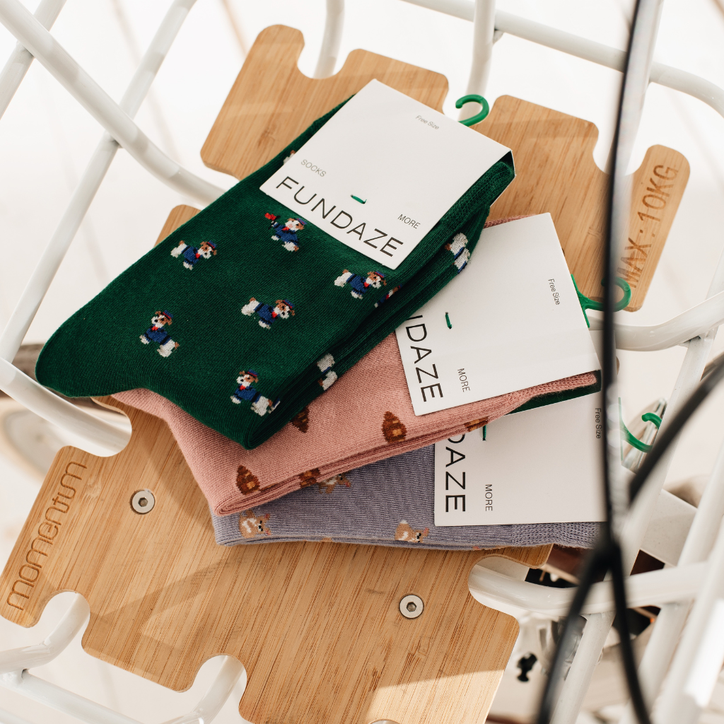 „Modischer Lifestyle-Shot: Fliederfarbene Socken mit süßem Corgi-Hundemotiv, kombiniert mit sportlichen Sneakern beim Fahrradfahren. Ein perfektes Accessoire für einen lässigen Urban-Look.“